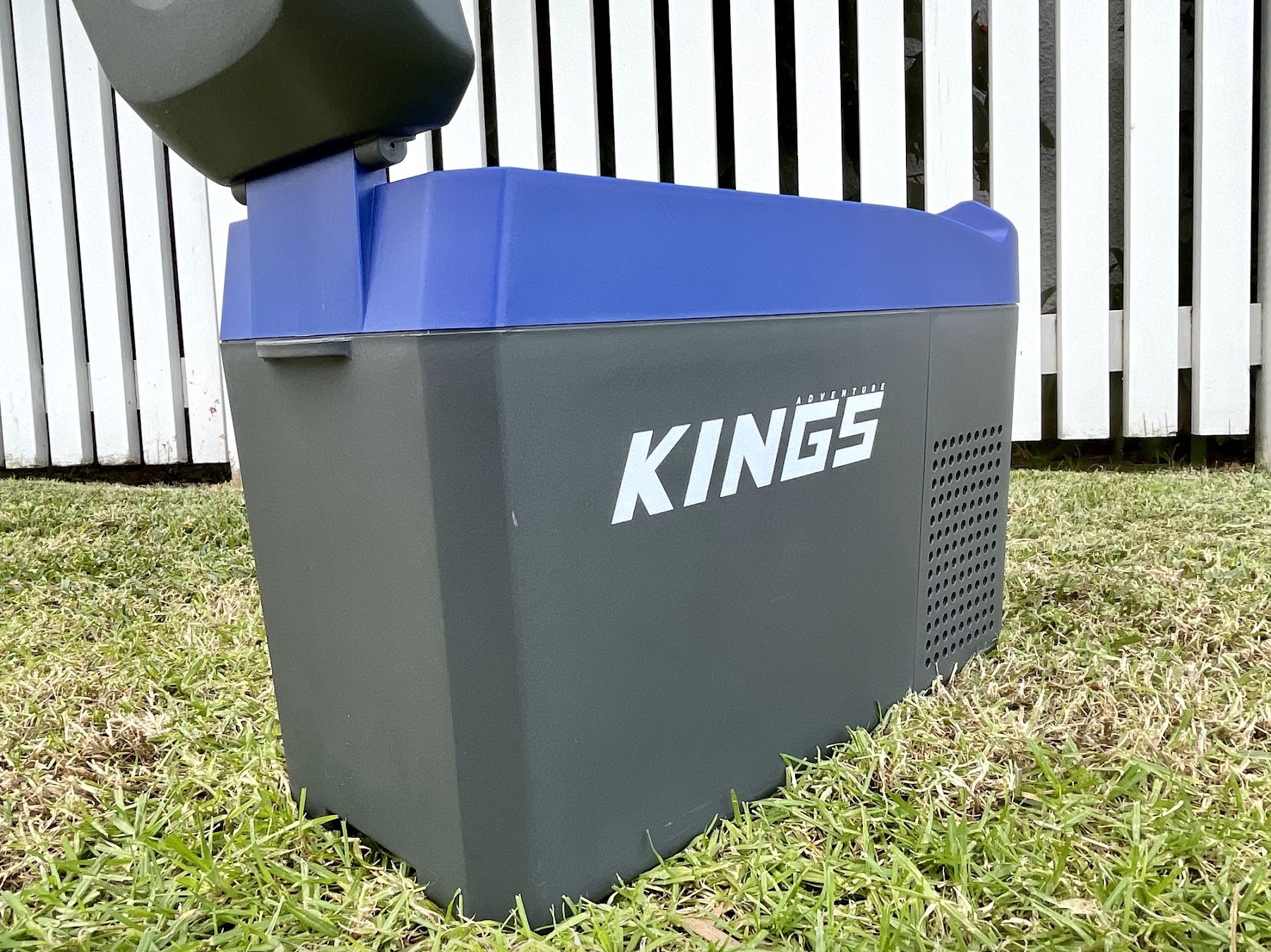 Kings 12V fridge center console in grass with lid open back side