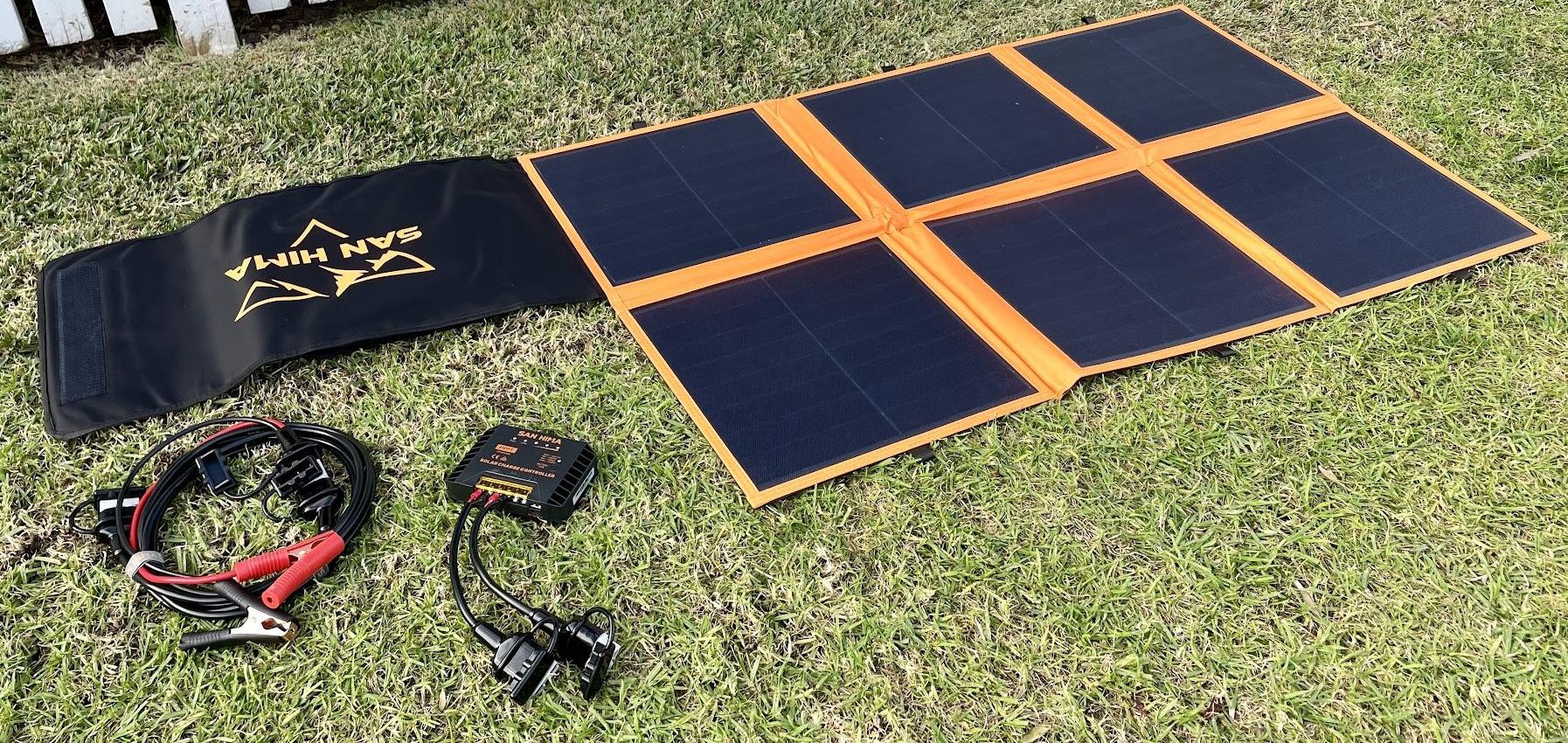 Unfolded San Hima 160W solar blanket with included accessories in grass