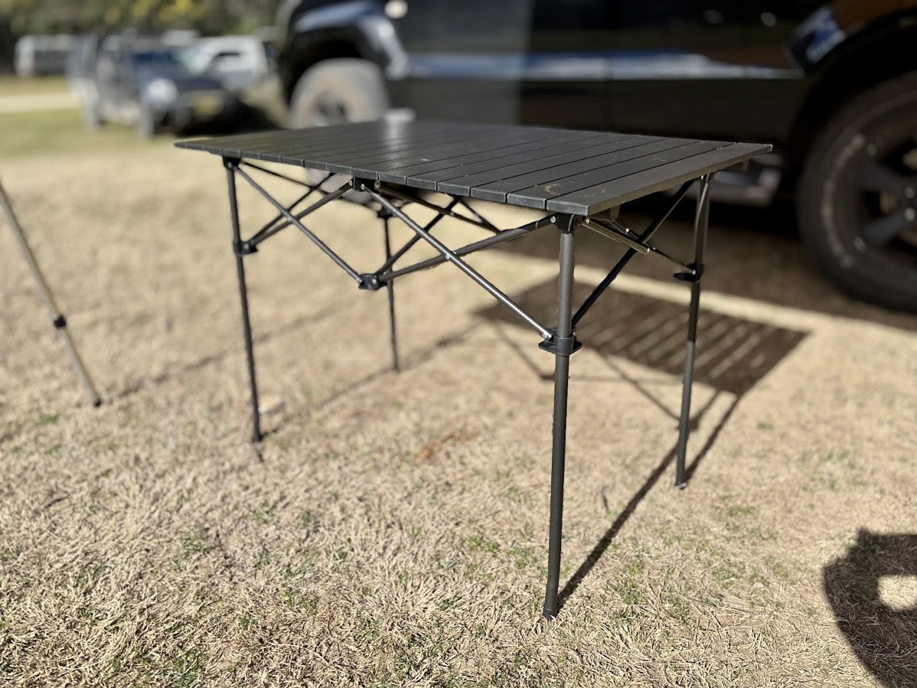 Assembled Kings camp roll-up table next to car at Coorongooba Campground