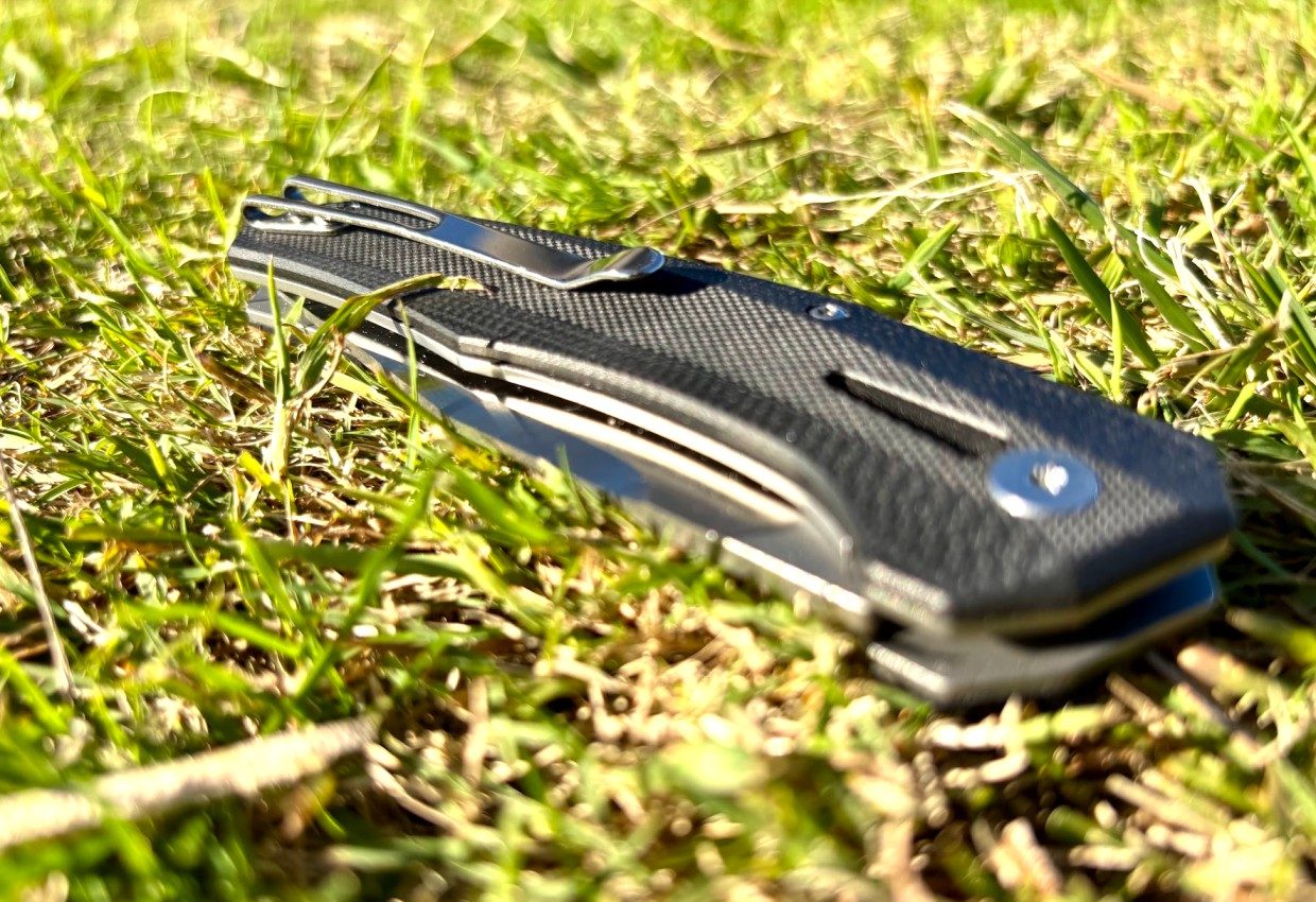 Folded G10 camping knife in grass