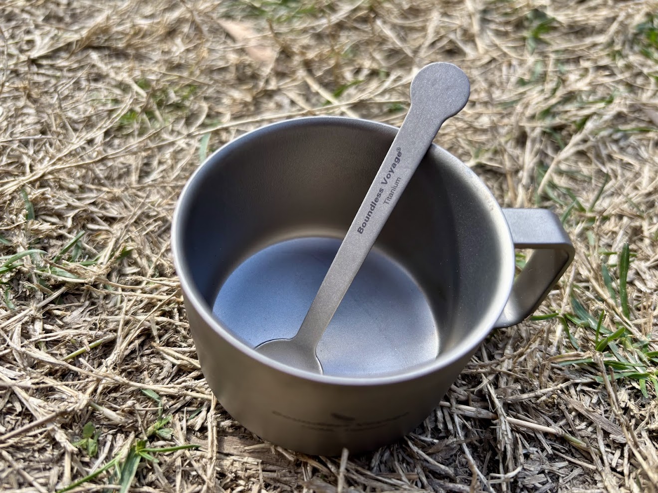 Titanium coffee spoon in titanium coffee mug in grass