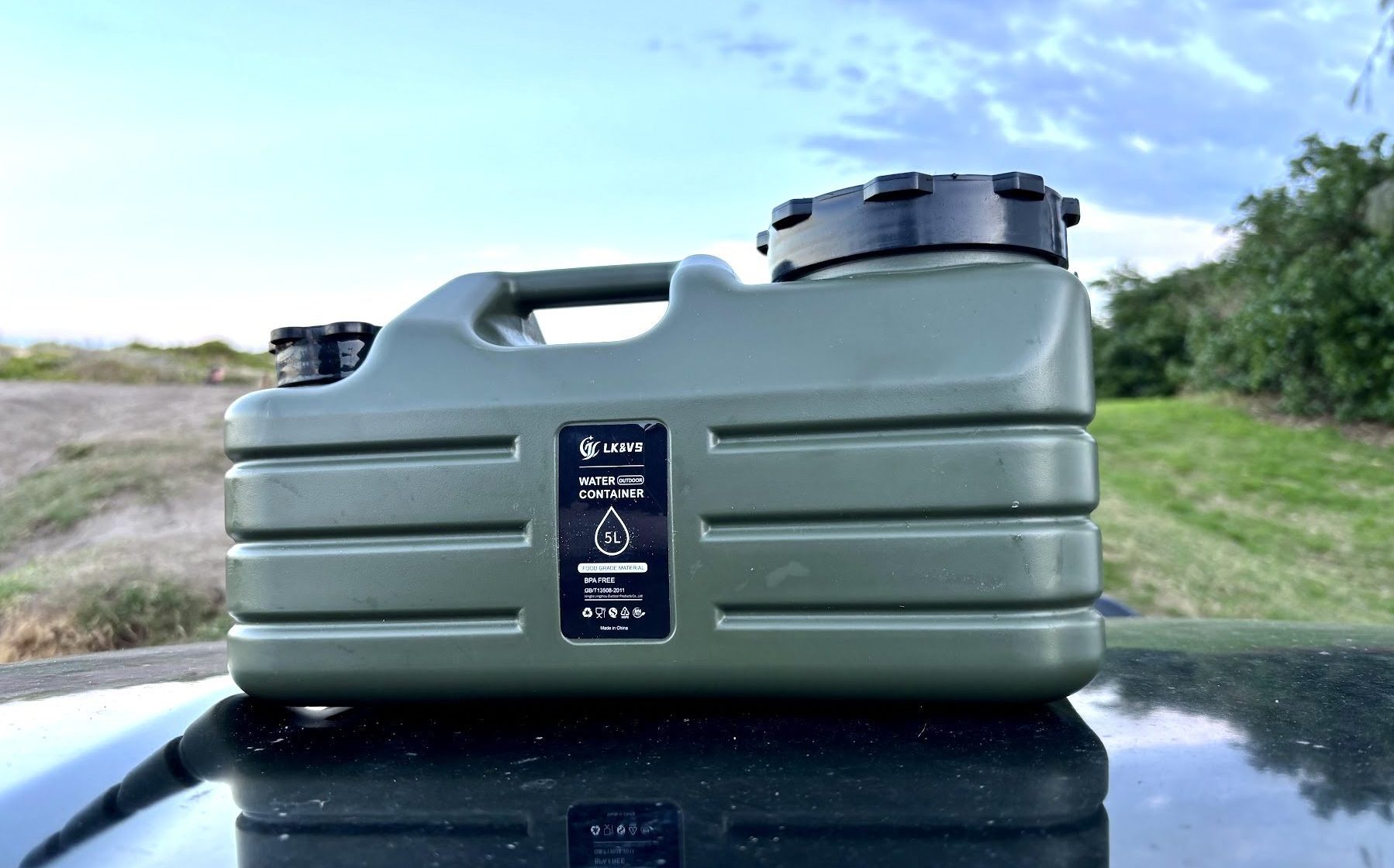 Army green 5L water container on top of bonnet