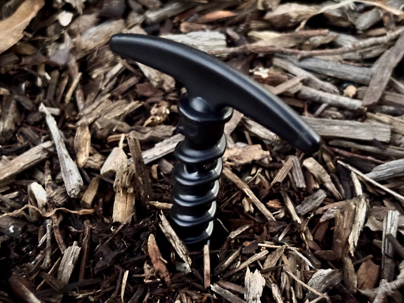 Nylon spiral tent pegs​ screwed in bush ground at campground