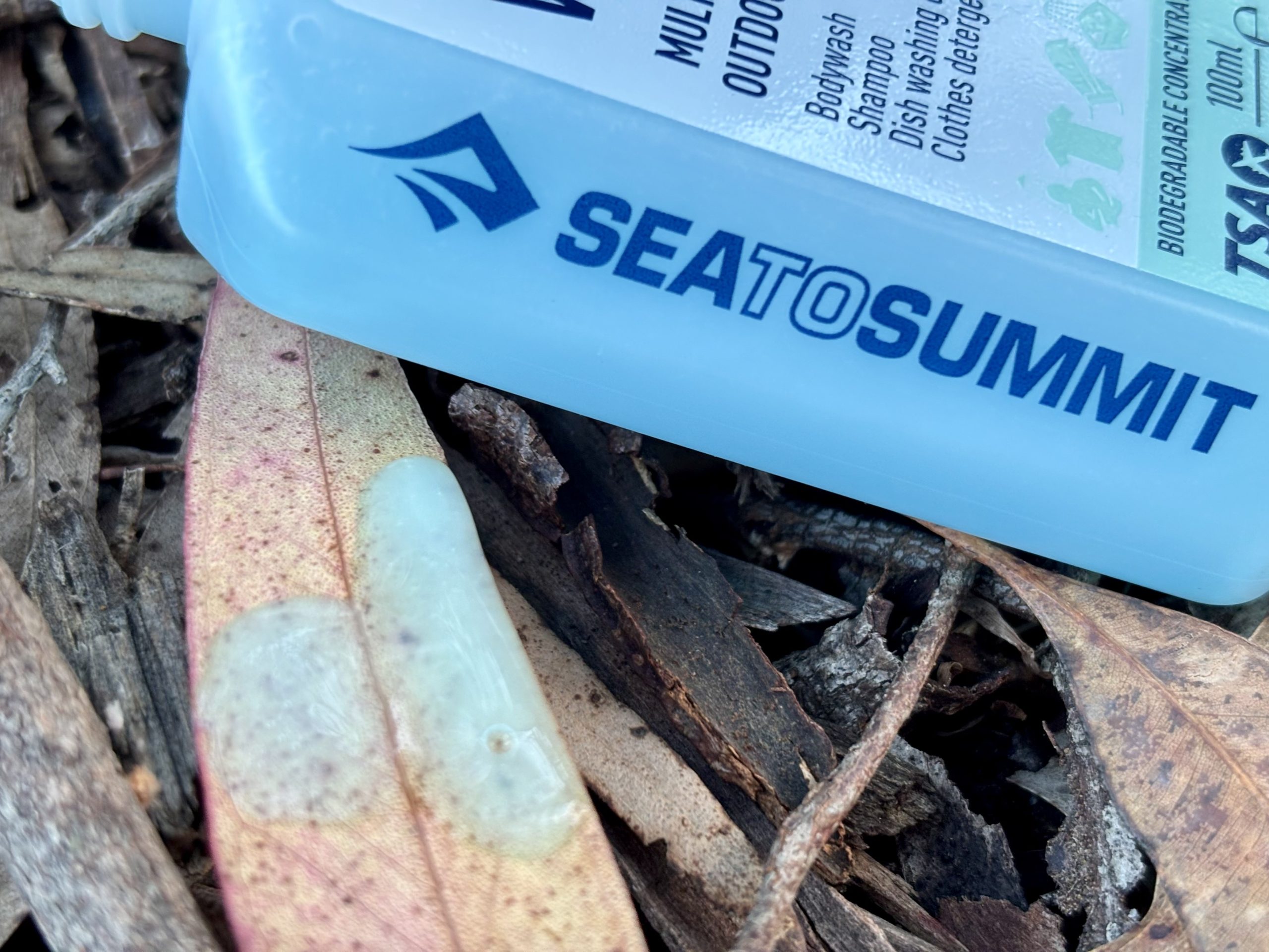 Side view of Sea to Summit camping soap bottle in forest