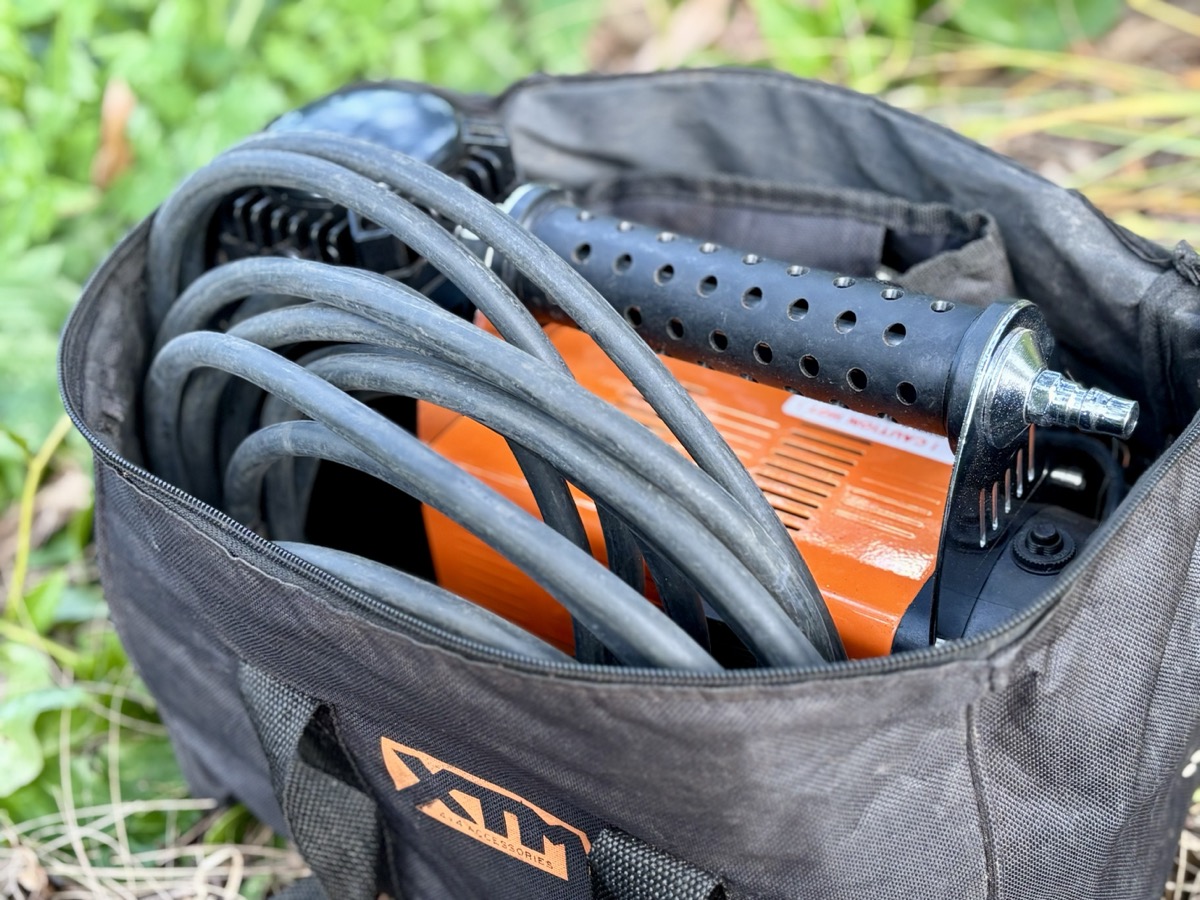 The XTM 150 psi 160lpm air compressor​ sits in a sturdy case with the hose and clamps tucked in neatly