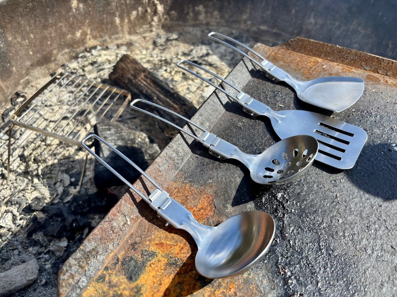 The handles of these folding camp utensils​ are long enough (approx 20 cm) to keep your hands away from the heat of the fire or camp stove