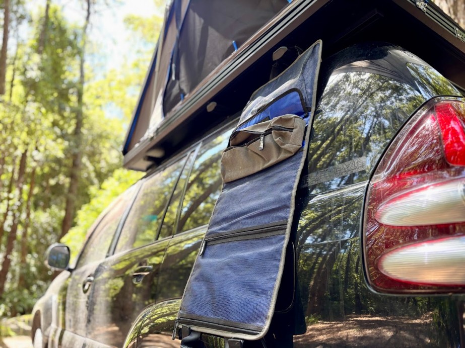 Hooking the Kings hanging camp caddy around one of the roof crossbars on the side of the car transforming it into great vertical storage